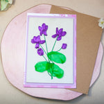 Ръчно бродирана картичка с теменужки, изработена със сатенени панделки